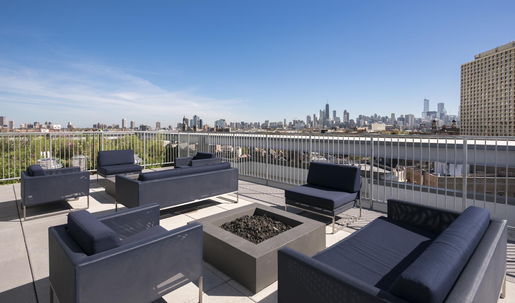 a group of couches on a rooftop overlooking a city