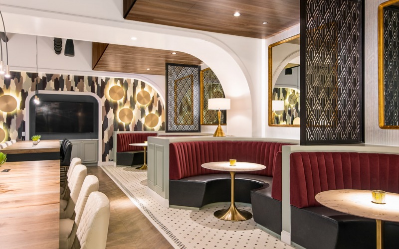 Resident clubhouse with ample seating, fireplace, demo kitchen and TVs